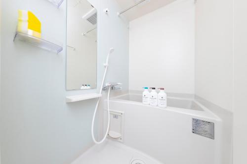 a white bathroom with a sink and a mirror at Tsubaki in Tokyo