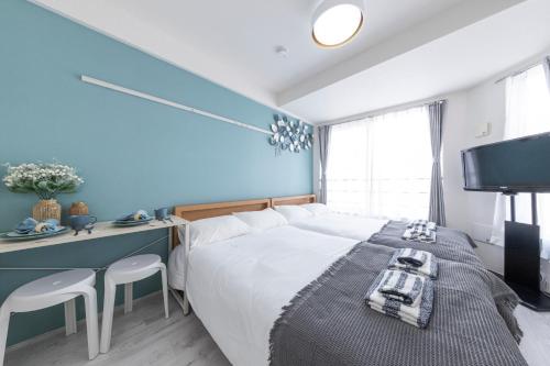 a bedroom with a large bed and a blue wall at Tsubaki in Tokyo