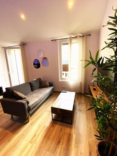 un salon avec un canapé et une table dans l'établissement Appart Mezzanine, Centre-ville, à Istres