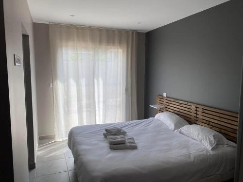 une chambre avec un grand lit avec des serviettes dessus dans l'établissement Les Villas Gîtes de Vertrieu, à Vertrieu