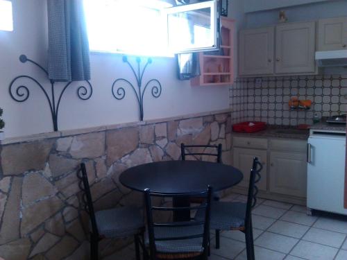 a kitchen with a table and chairs in a kitchen at Eleni Studios in Agios Nikolaos