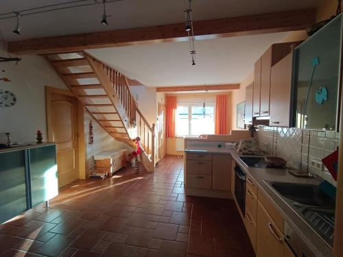 a kitchen with a staircase leading to a stair case at Ferienhaus - gemütlich und traditionell auf 90 m2 in Fürstenfeld
