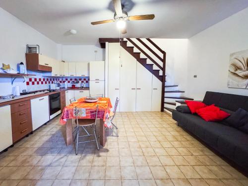a kitchen and living room with a table and a couch at Villetta a schiera su due livelli con giardino in Metaponto
