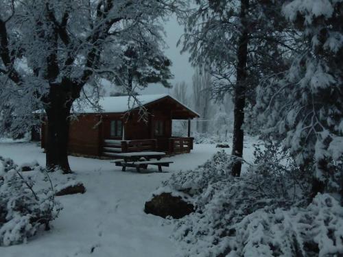 a cabin with a picnic table in the snow at El Llano de los Conejos Serranía de Cuenca in Cañamares