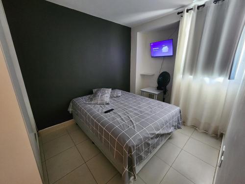 a small bedroom with a bed with a gray blanket at 4º Città Residence - Piscina e academia in Brasília