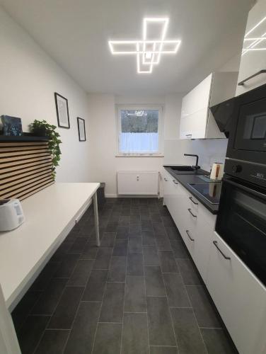 a kitchen with white cabinets and a black stove at Ferienwohnung in einer idyllischen Lage in Bremerhaven