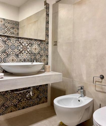 a white bathroom with a sink and a toilet at Over The Sea Punta Lada in Porto Rotondo