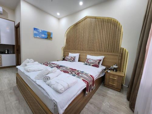 a bedroom with a large bed with towels on it at Volidam Hotel in Samarkand