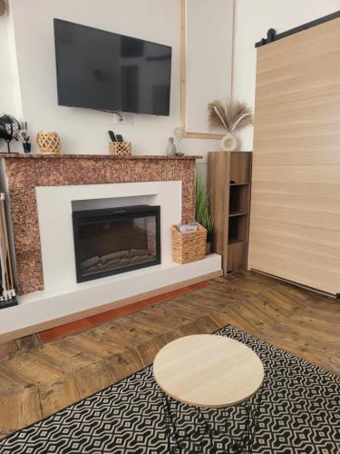 Il comprend un salon doté d'une cheminée et d'une télévision à écran plat. dans l'établissement Appartement au cœur de ville, à Embrun