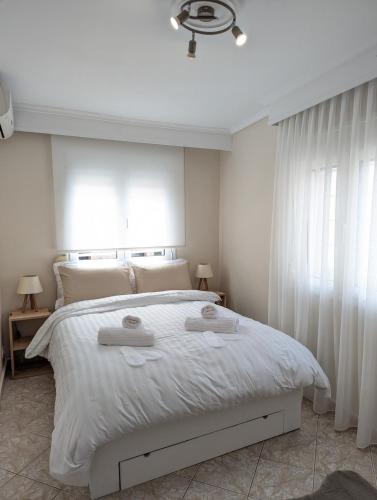 a bedroom with a white bed with two towels on it at Under Castle Walls cottage in Thessaloniki