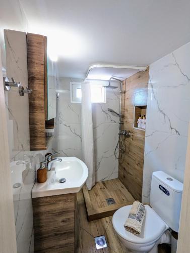 a white bathroom with a sink and a toilet at Under Castle Walls cottage in Thessaloniki