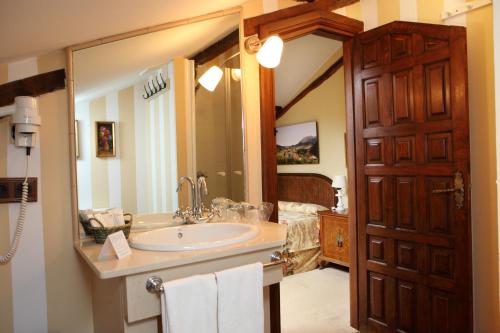 a bathroom with a sink and a large mirror at Posada La Torre de La Quintana in Liendo
