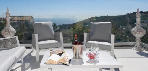 a table with a bottle of wine and two chairs at Villa Caruso in Massa Lubrense
