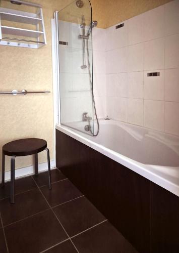 La salle de bains est pourvue d'une baignoire avec un tabouret. dans l'établissement St-Goustan à bâbord - Les Gîtes de la Côte d'Amour, au Croisic