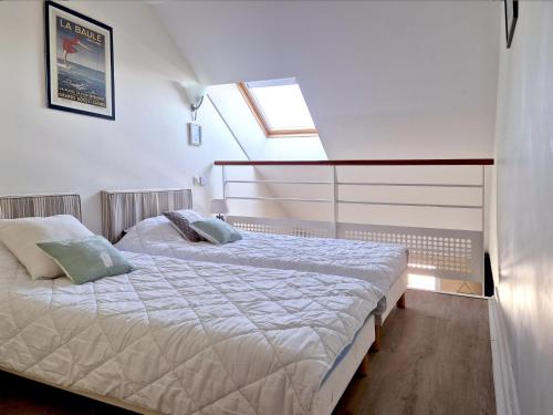 une chambre avec deux lits et une fenêtre dans l'établissement St-Goustan à bâbord - Les Gîtes de la Côte d'Amour, au Croisic