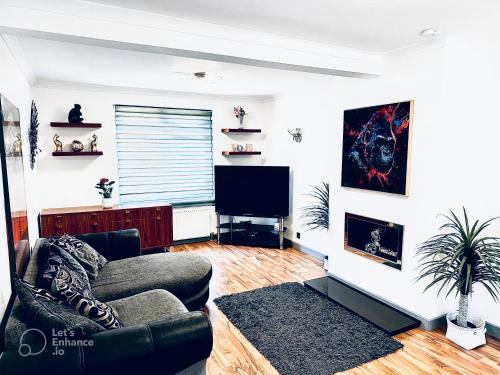 a living room with a couch and a flat screen tv at Grace Court in Aberdeen