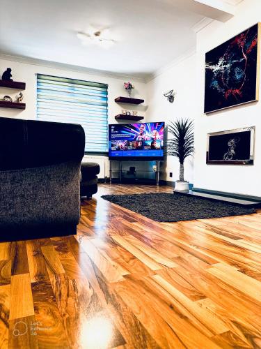 a living room with a wooden floor and a flat screen tv at Grace Court in Aberdeen