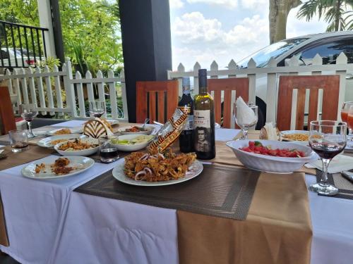 a table with plates of food and a bottle of wine at Dew Drops Nature Villa in Parakaduwa