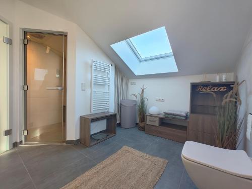 a bathroom with a toilet and a skylight at Marina-Penthouse 625 in Zielow