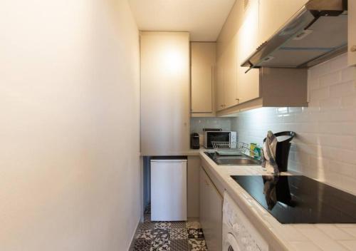 une petite cuisine avec un évier et un micro-ondes dans l'établissement Magnifique appartement - 15 minutes a pieds PALAIS, à Cannes