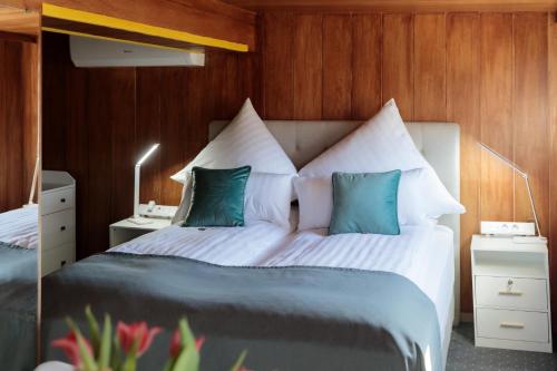 a bedroom with a large bed with blue and white pillows at Boutique-Hotel Weisses Haus Art in Bad Kissingen