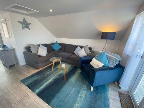 una sala de estar con un sofá y una mesa en By the beach, with sea views and spectacular sunsets, en Westward Ho