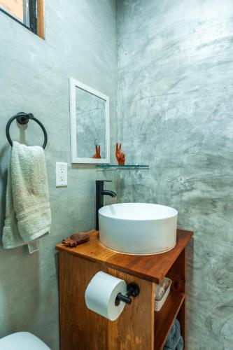 a bathroom with a white sink on a wooden counter at MALU Cabins in Bocas del Toro