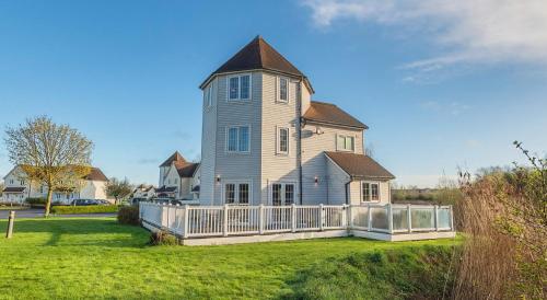 a large house with a tower on top of a yard at Windrush Turret Lodge in South Cerney
