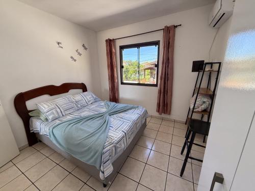 Un dormitorio con una cama y una ventana en Residencial Santinho, en Florianópolis