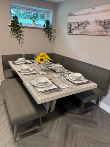 a table with plates and glasses and flowers on it at The Drey in Poole