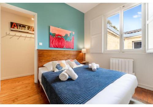 une chambre avec un lit aux murs bleus et une fenêtre dans l'établissement Appartement en Hypercentre - Le Teulère, à Bordeaux