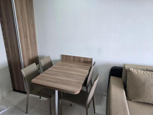 a wooden table and chairs in a room with a couch at Apartamentos em Rio Quente com maravilhosa área de lazer e excelente localização in Rio Quente