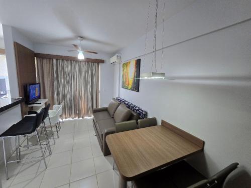 a living room with a couch and a table at Apartamentos em Rio Quente com maravilhosa área de lazer e excelente localização in Rio Quente