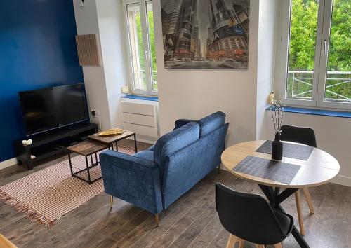 ブレストにあるAppartement moderne proche commercesの青いソファとテーブルのあるリビングルーム