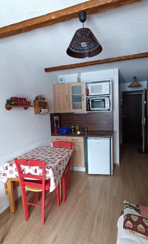 une cuisine avec une table et une cuisine avec une salle à manger dans l'établissement Le Cocon Puy-St-Vincent, à Puy-Saint-Vincent