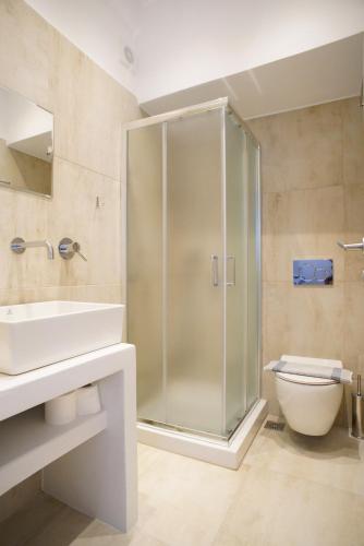 a bathroom with a shower and a toilet and a sink at Casa di Flora in Loutra