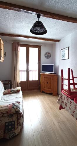 une chambre avec un lit et une télévision dans une pièce dans l'établissement Le Cocon Puy-St-Vincent, à Puy-Saint-Vincent