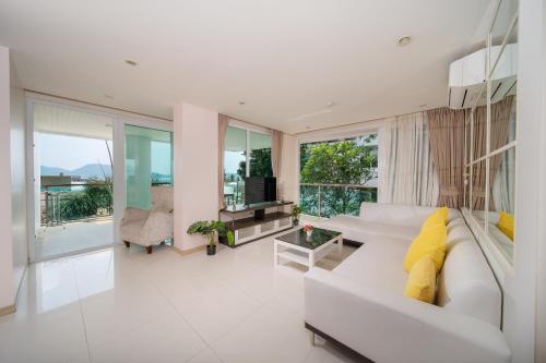 a living room with a white couch and large windows at Patong Kalim Unparalleled Sea View B&B Resort in Patong Beach