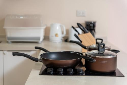 two pots and pans on a stove in a kitchen at Patong Kalim Unparalleled Sea View B&B Resort in Patong Beach