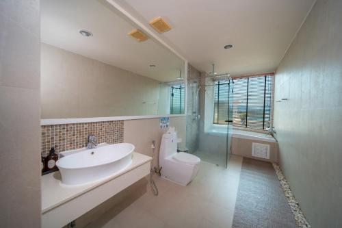 a bathroom with a sink and a toilet and a mirror at Patong Kalim Unparalleled Sea View B&B Resort in Patong Beach
