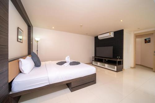 a bedroom with a bed and a flat screen tv at Patong Kalim Unparalleled Sea View B&B Resort in Patong Beach