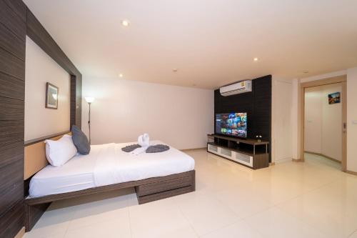 a bedroom with a bed and a flat screen tv at Patong Kalim Unparalleled Sea View B&B Resort in Patong Beach