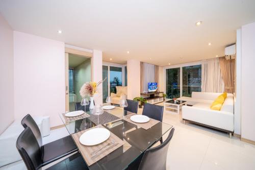 a dining room and living room with a table and chairs at Patong Kalim Unparalleled Sea View B&B Resort in Patong Beach