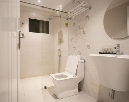 a white bathroom with a toilet and a shower at 44 Oasis in Chennai