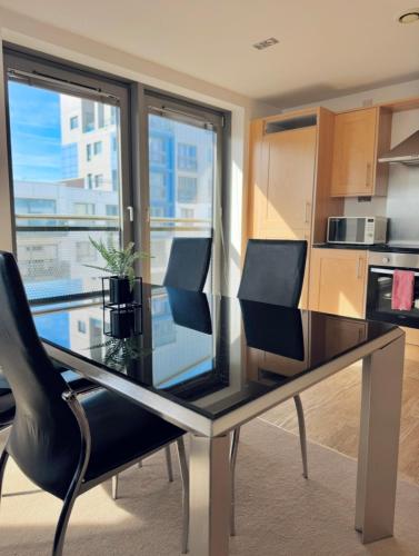 a dining room table with chairs and a kitchen at Modern Two Bedroom Apartments in Edinburgh