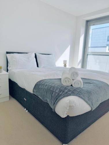 a bedroom with a bed with two towels on it at Modern Two Bedroom Apartments in Edinburgh