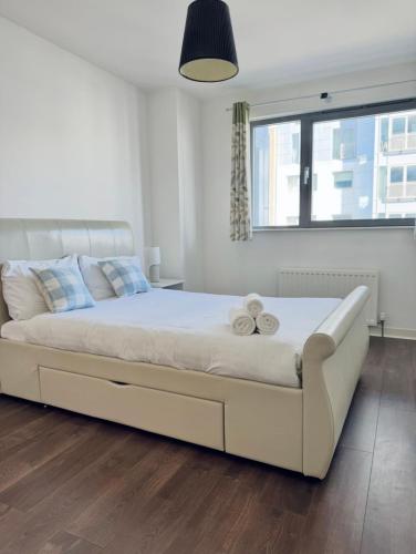 a bedroom with a large white bed with two towels at Modern Two Bedroom Apartments in Edinburgh
