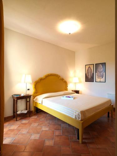 a bedroom with a bed with two lamps and two tables at Le Corti Del Sole Residence in Venturina Terme