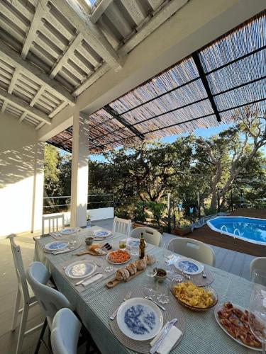 a dining table with plates of food and a pool at Casa Alana in Mira