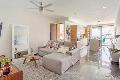 a living room with a couch and a table at It Beach Condo in Playa del Carmen
